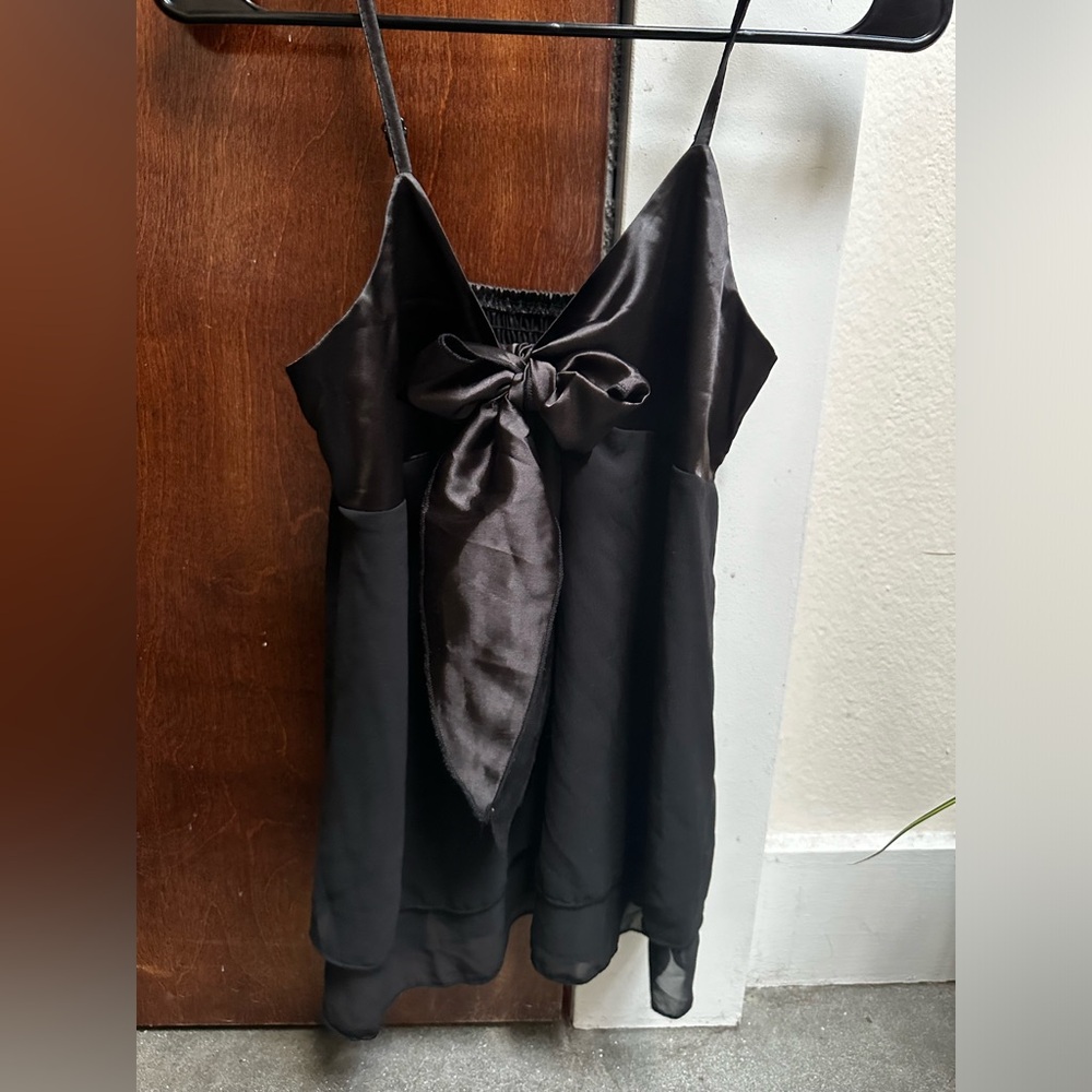 cute black flowey top with a big bow on the front